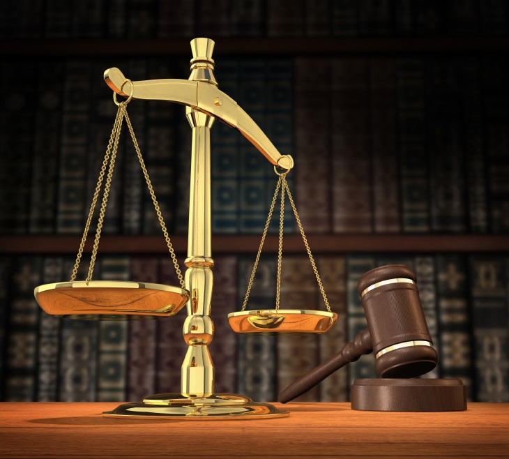 Scales of justice and gavel on desk with dark background that allows for copyspace. court
