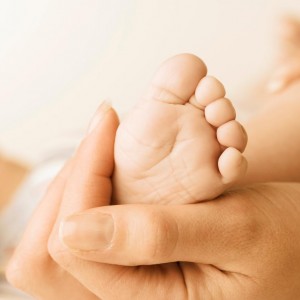 mother holding baby's foot