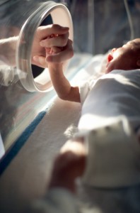 infant holding mother's hand